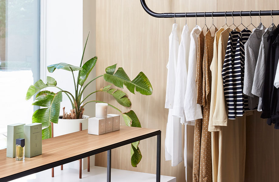 5794-NG Beige Elm wall behind hanging clothes with 5795-NG Camel Elm retail table